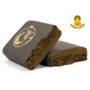 Dark pressed Lebanese hash slab with a gold embossed seal, traditional 1g resin-rich hash